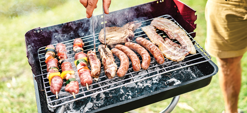 Close up of man grilling food on a barbeque